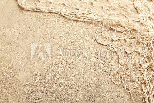 Fototapeta Fishing net on a beach sand