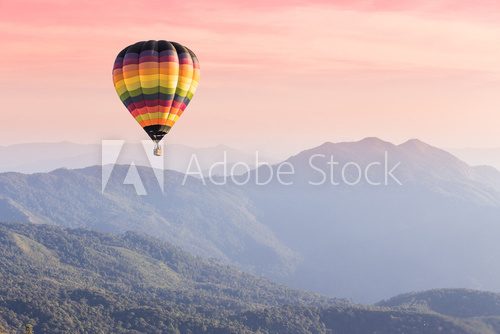 Fototapeta Hot air balloon above high mountain at sunset