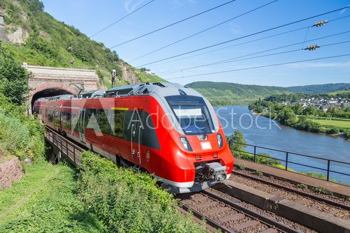 Fototapeta Intercity train leaving a tunnel near the river Moselle in Germa