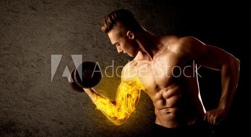 Fototapeta Muscular bodybuilder lifting weight with flaming biceps concept