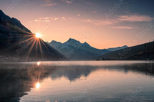 Fototapeta Sunrise on mountain with foggy in Medicine lake at Jasper