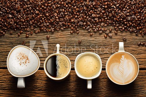Fototapeta Variety of cups of coffee and coffee beans on old wooden table