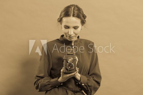 Fototapeta Woman taking picture with old camera