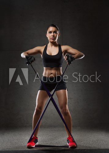 Fototapeta woman with expander exercising in gym