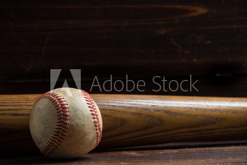 Fototapeta A wooden baseball bat and ball on a wooden background