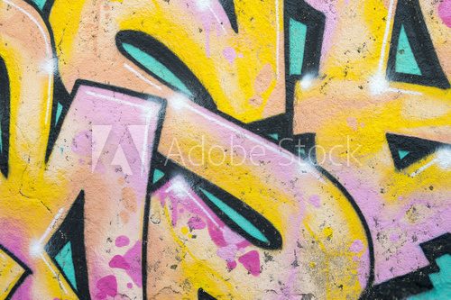 Fototapeta Abstract urban background of graphic letters of a colorful graffiti tag in pink, yellow and blue in the Lapa neighborhood of Rio de Janeiro, Brazil