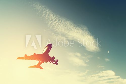 Fototapeta Airplane taking off at sunset. Silhouette of a flying aircraft