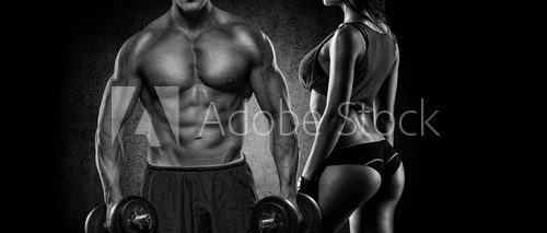 Fototapeta Athletic man and woman with a dumbbells