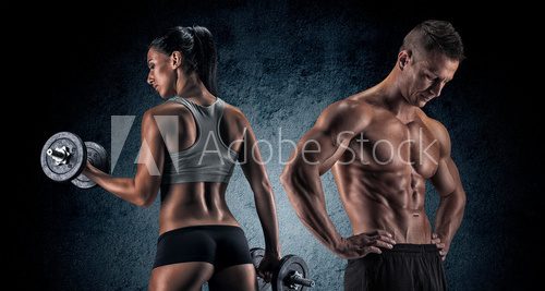 Fototapeta Athletic man and woman with a dumbells.