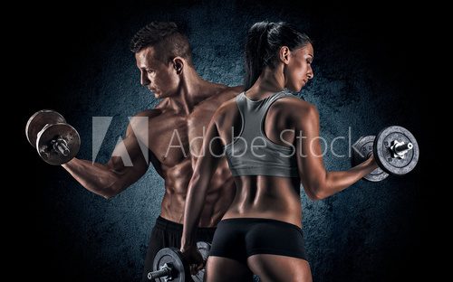 Fototapeta Athletic man and woman with a dumbells.
