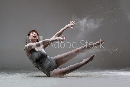 Fototapeta Beautiful expressive ballet dancer posing with flour at studio