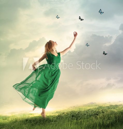 Fototapeta Beautiful girl catching butterflies on a mountain