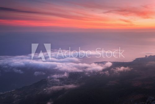 Fototapeta Beautiful landscape with sea, colorful sunset and low clouds. Nature background