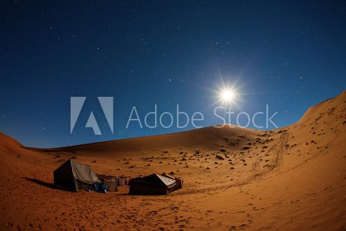Fototapeta Camp in Sahara Desert in night with moon as star and moving star