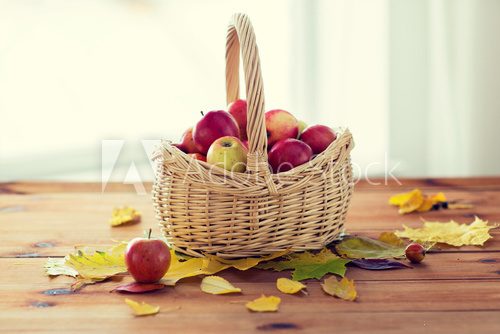 Fototapeta close up of basket with apples on wooden table