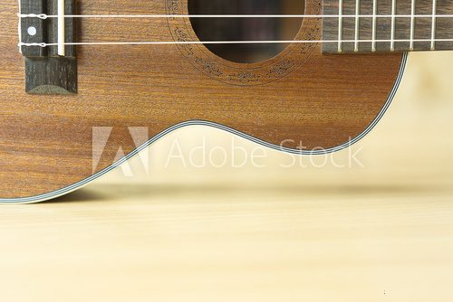 Fototapeta Close up of wooden ukulele on wooden background