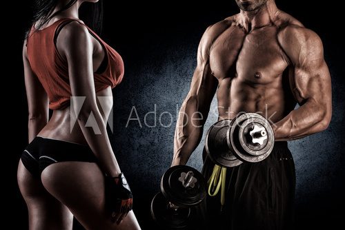 Fototapeta Closeup of a muscular young man lifting weights