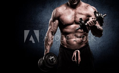 Fototapeta Closeup of a muscular young man lifting weights on dark backgrou