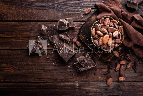 Fototapeta Cocoa beans and chocolate on wooden background