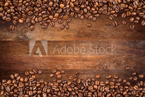Fototapeta coffee background with beans on rustic old oak wood