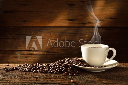 Fototapeta Coffee cup and coffee beans on old wooden background