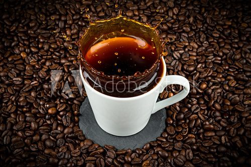 Fototapeta coffee cup with splash on coffee beans background