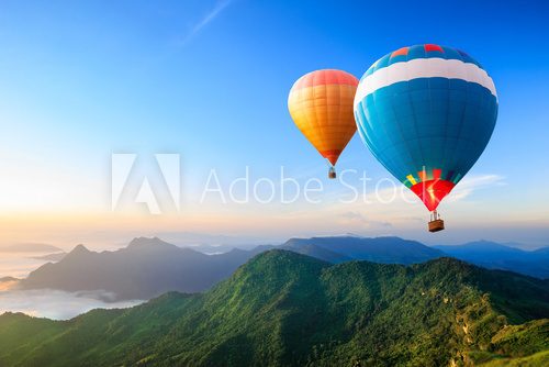 Fototapeta Colorful hot-air balloons flying over the mountain