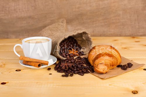 Fototapeta cup of coffee and coffee beans on a wooden surface