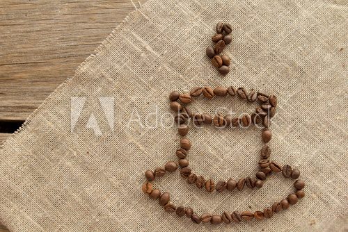 Fototapeta Cup of coffee beans on linen top view