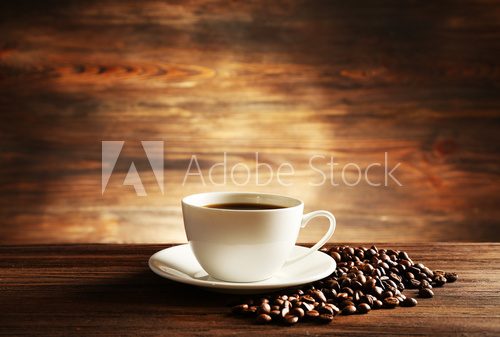Fototapeta Cup of coffee with grains on wooden background