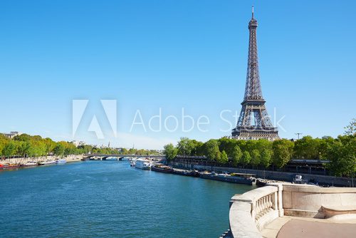 Fototapeta Eiffel tower and empty white balustrade on Seine river in a clear day