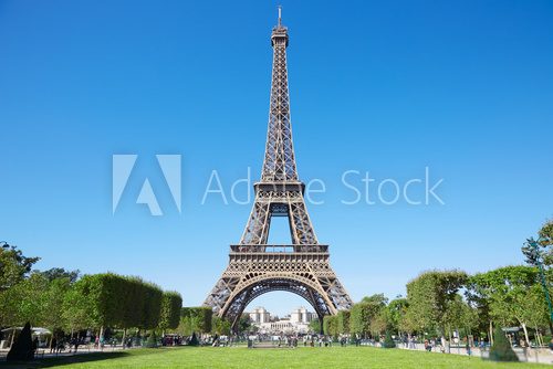 Fototapeta Eiffel tower, sunny summer day with blue sky and green Field of Mars