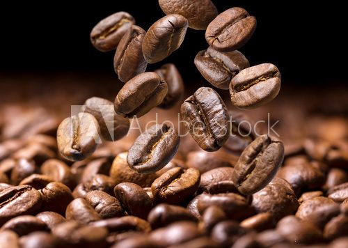 Fototapeta Falling coffee beans. Dark background with copy space, close-up