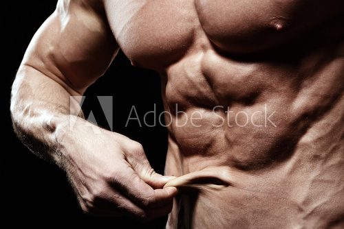 Fototapeta Fit and no fat young man showing abs and thin skin around belly