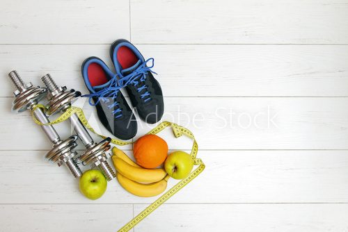 Fototapeta fitness equipment and fruits on white wooden plank floor