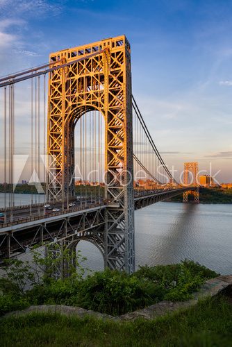 Fototapeta George Washington Bridge crossing the Hudson River connecting Fort Lee, New Jersey and Upper Manhattan, New York City. The towers of the suspension bridge are lit by the sunset light.