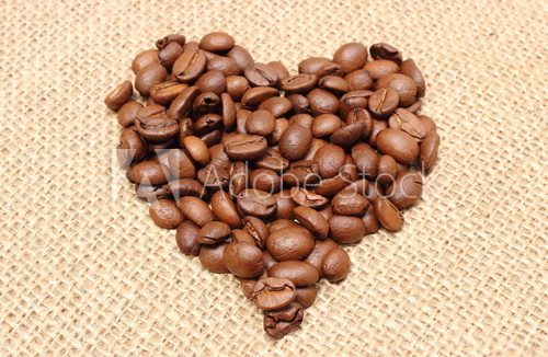 Fototapeta Heart shaped coffee beans on jute background