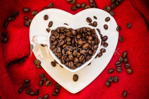 Fototapeta Heart shaped cup with coffee beans on red