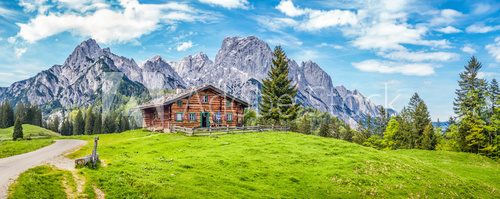 Fototapeta Idyllic landscape in the Alps with mountain chalet and green meadows