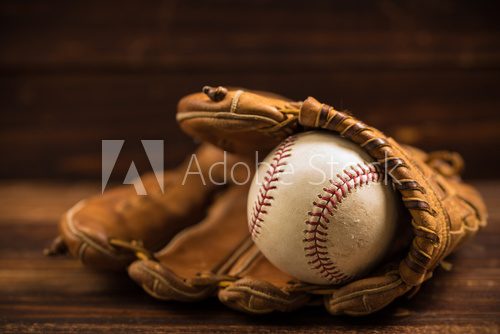 Fototapeta Leather baseball glove and ball on a wooden bench