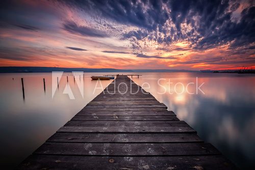 Fototapeta Magnificent lake sunset with boats and a wooden pier