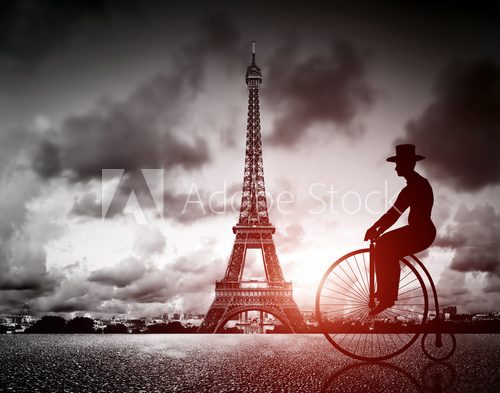 Fototapeta Man on retro bicycle next to Effel Tower, Paris, France.