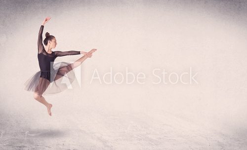 Fototapeta Modern ballet dancer performing art jump with empty background