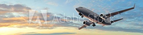 Fototapeta Modern Passenger airplane flight in sunset panorama