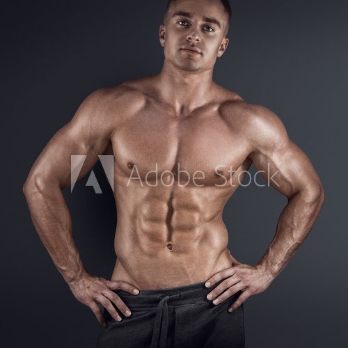 Fototapeta Muscular man in dark background
