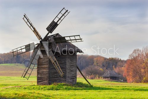 Fototapeta Old windmill on a background of forest and sky