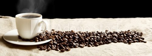 Fototapeta Panoramic view of frothy coffee cup with beans on fabric flax