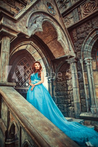 Fototapeta Princess in blue dress is going to open the castle door.