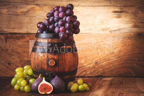 Fototapeta Red and white grapes on a rural wooden barrel