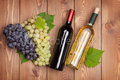 Fototapeta Red and white wine bottles and bunch of grapes